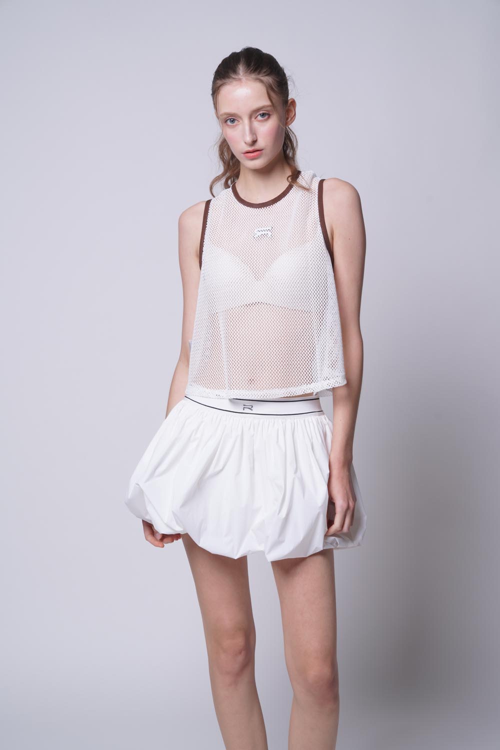 Female model wearing Ramsports Court Flow Scoop Tank in white