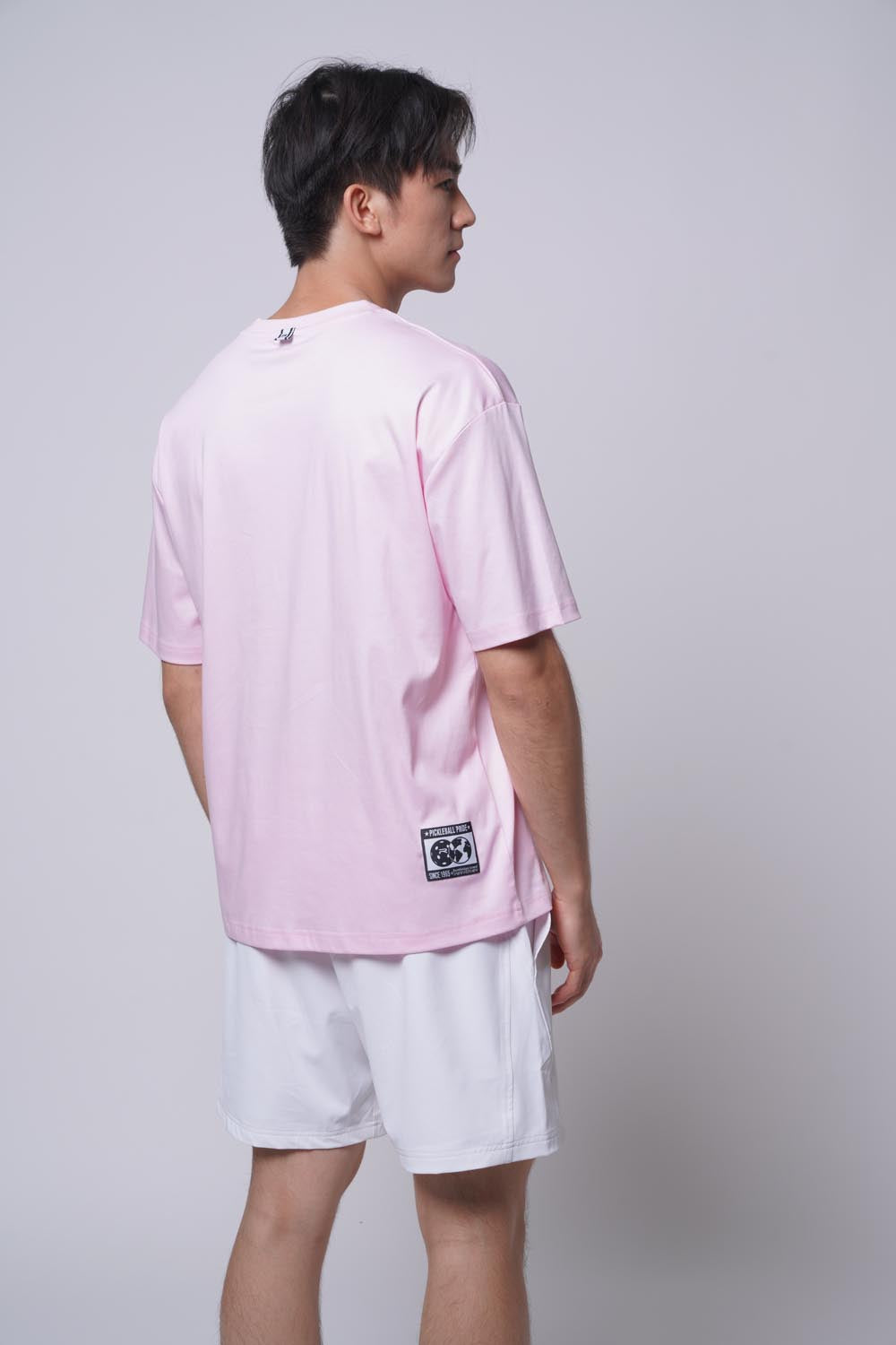 Asian male model standing facing away wearing Ramsports Court Moods Icon Grid T-shirt in pink