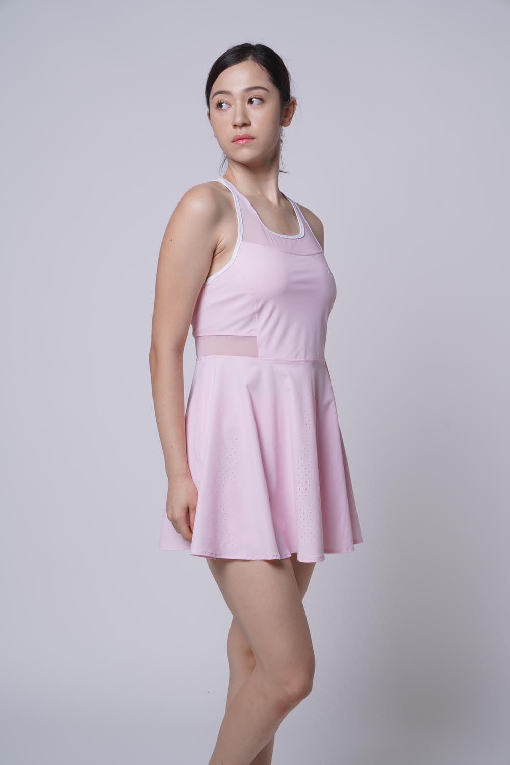 Asian female model looking away on the other side, with her leg bent in front as she's wearing Pink Ramsports Racer Flare Dress.