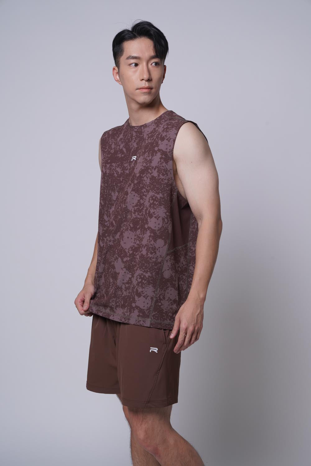 Asian male model standing with tee top or sleeve less shirt paired with Ramsports MatchDay Core Short in brown
