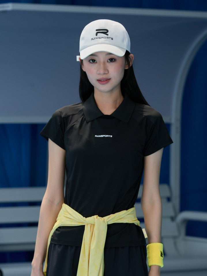 Asian female model wearing an all-black outfit with Ramsports AirFlow Mesh Polo and black shorts with a yellow jacket wrapped around her hips