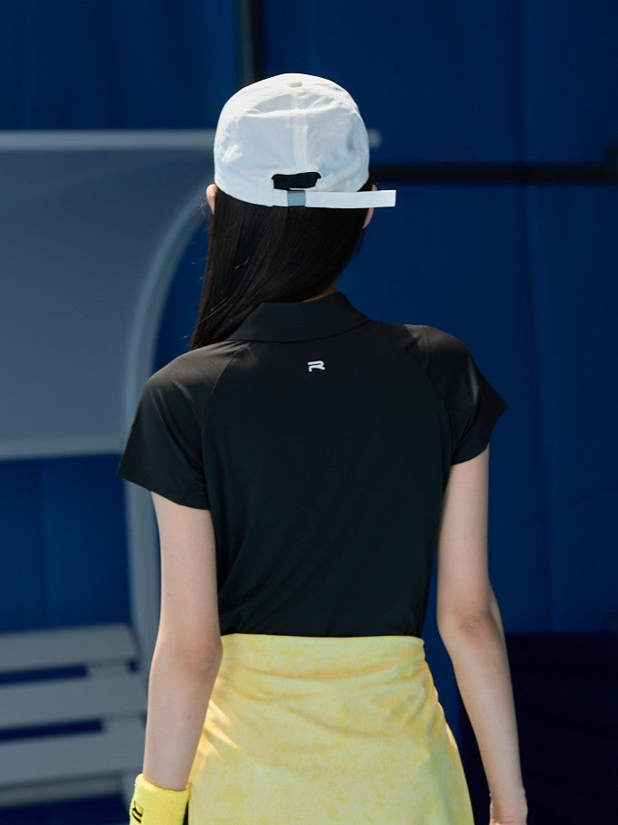 Asian female model facing away, wearing an all-black outfit with Ramsports AirFlow Mesh Polo and black shorts with a yellow jacket wrapped around her hips