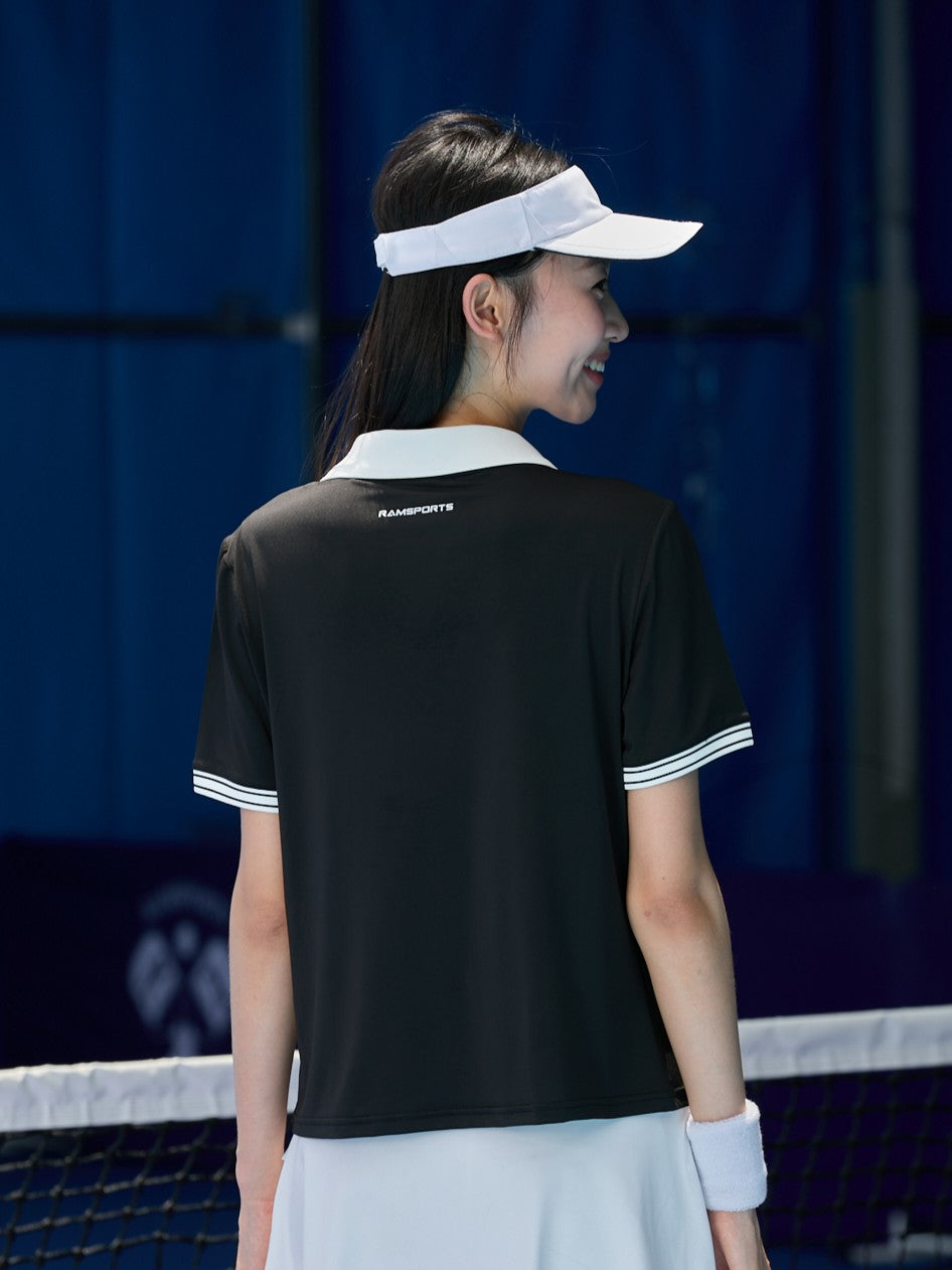Asian female model facing away, wearing a black Ramsports AirFlow V-Neck Polo and a white skort
