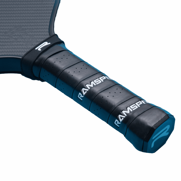 Side view of the Ramsports Ignis Pro Pickleball Paddle laid flat, focusing on the handle