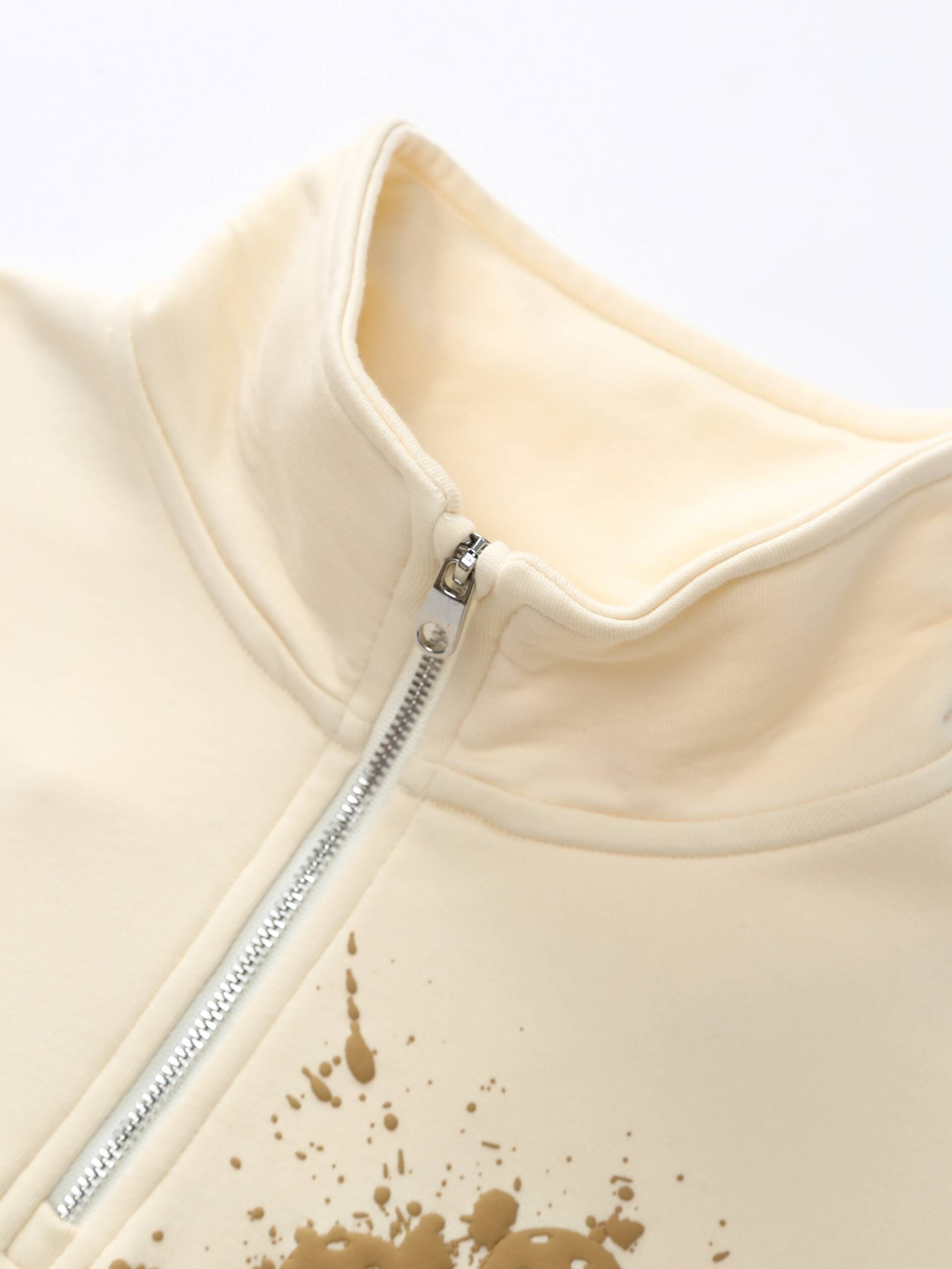 Zoomed-in image of the khaki Ramsports EcoSoft Half Zip Logo Sweatshirt, focusing on the hem area near the start of the zipper