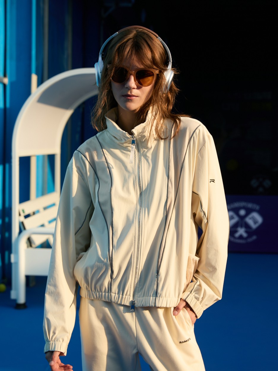 Female model wearing a khaki Ramsports FlexTek Block Jacket fully zipped up