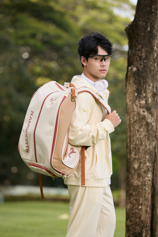Asian male model wearing the Ramsports Heritage DuoTone Backpack with one strap over his shoulder, looking at the camera