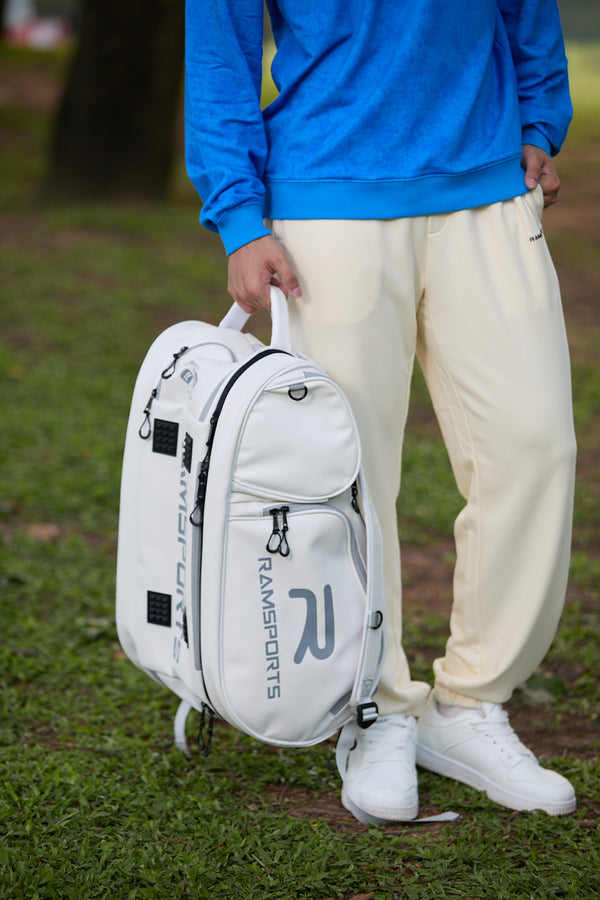 Asian male model standing and holding the Ramsports LiteCarry Arctic Backpack by the top strap