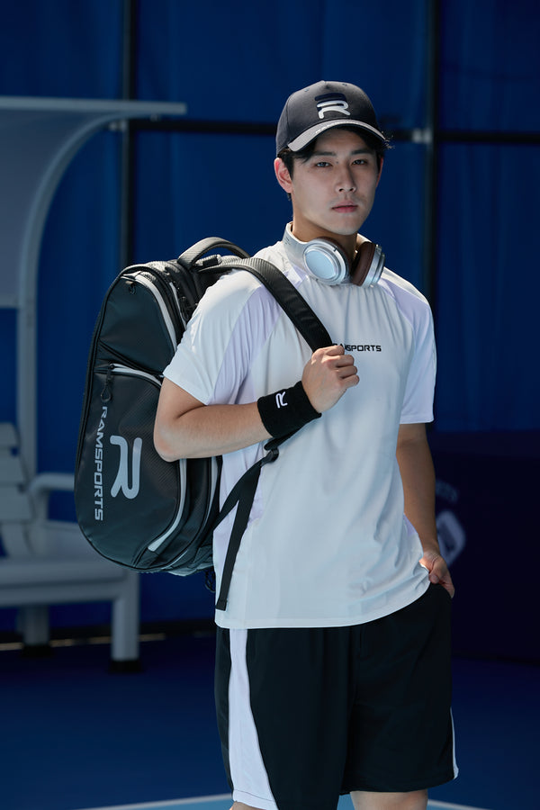 Asian male model with headphones around his neck, wearing the Ramsports LiteCarry Court Backpack and looking directly at the camera