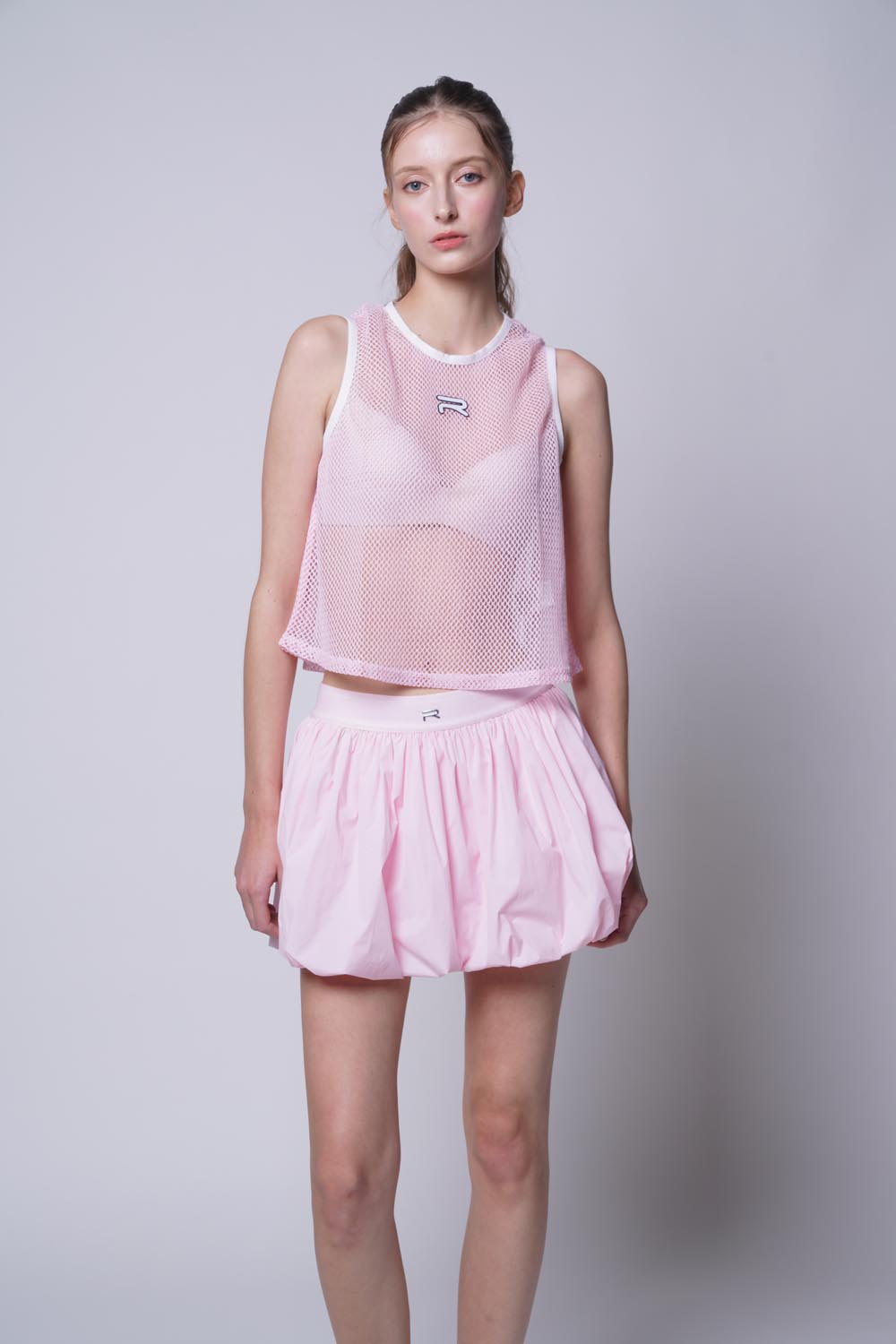 Female model wearing Court Flow Scoop Tank in pink