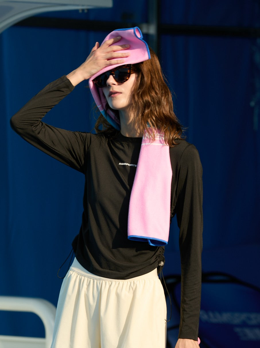 Female model wiping sweat with a pink towel, wearing a black Ramsports CoolDry Long-Sleeves Tee and light-colored shorts