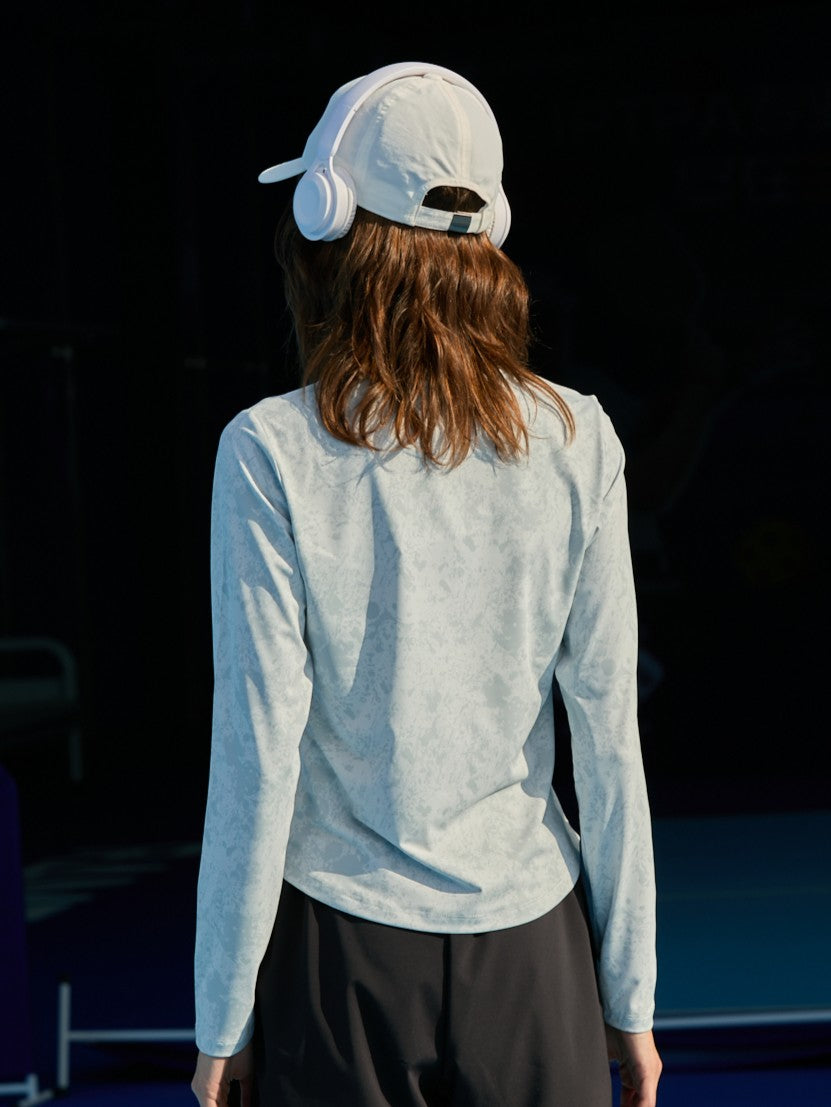 Asian female model turned away, wearing the Ramsports CoolDry Marble Print Long-Sleeves Tee in gray and black shorts.