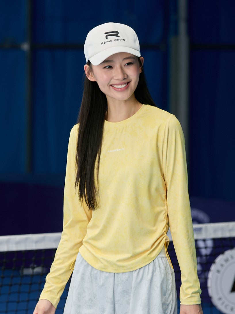 Asian female model wearing the Ramsports CoolDry Marble Print Long-Sleeves Tee in yellow paired with gray shorts.