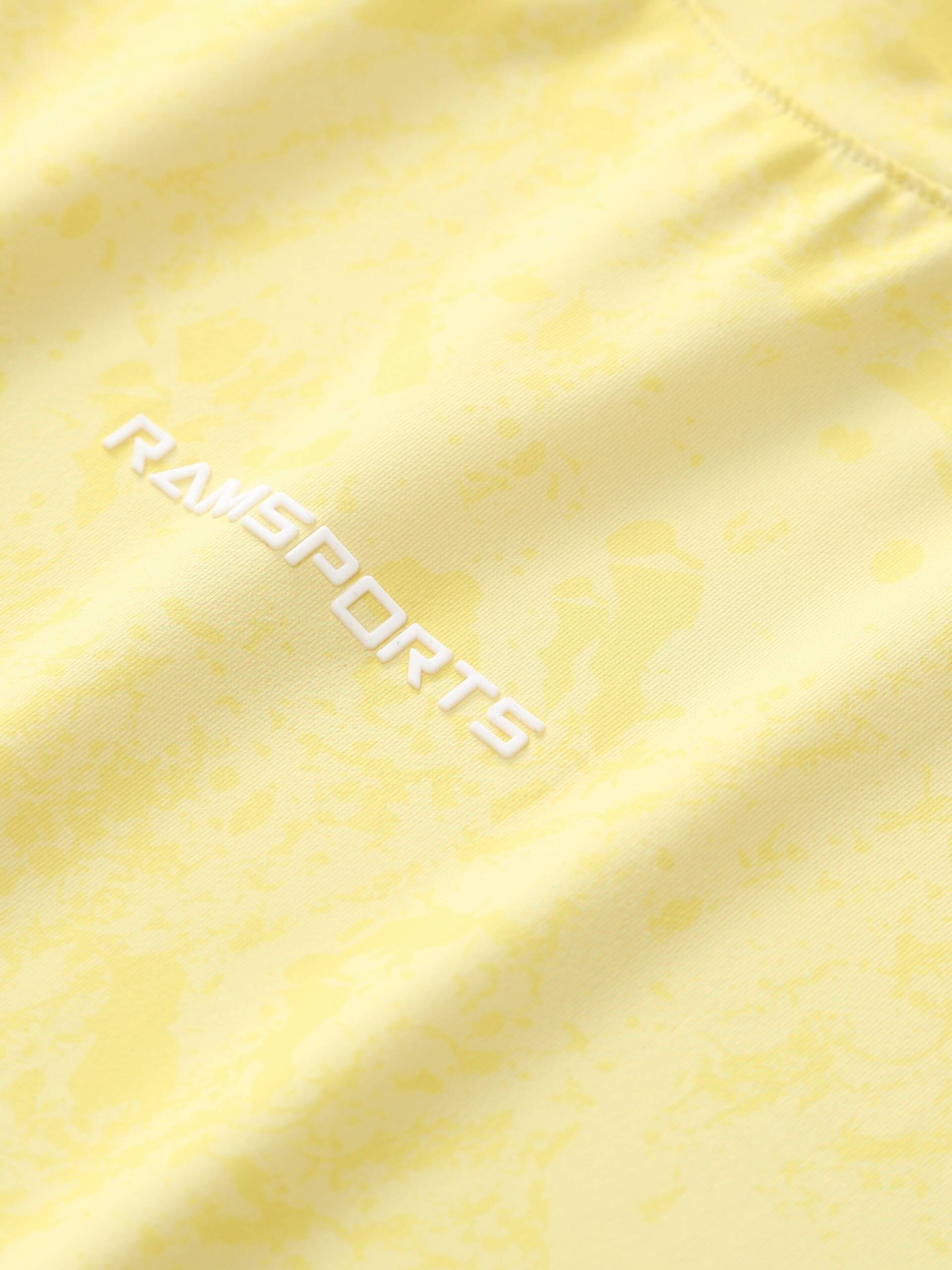 Close-up of the white Ramsports logo printed on the yellow Ramsports CoolDry Marble Print Long-Sleeves Tee