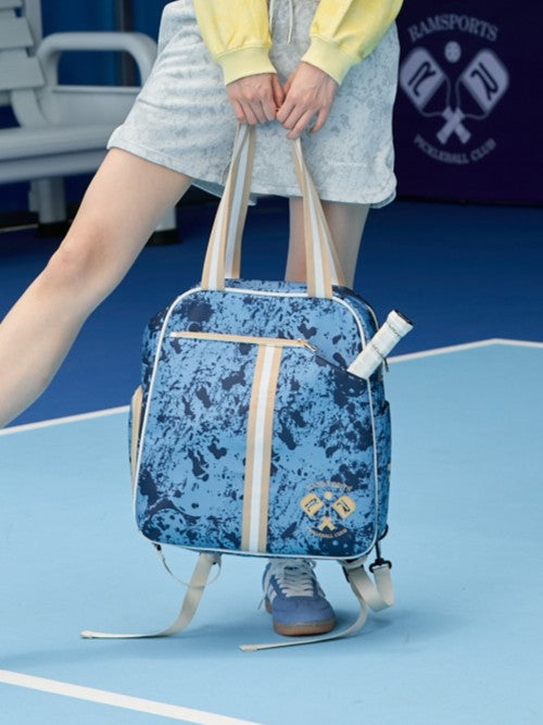 Cropped image of a female model holding the Ramsports Blue Court Luxe Tot bag