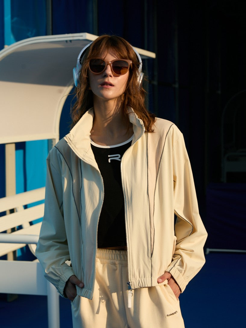 Female model wearing a khaki Ramsports FlexTek Block Jacket over a black top