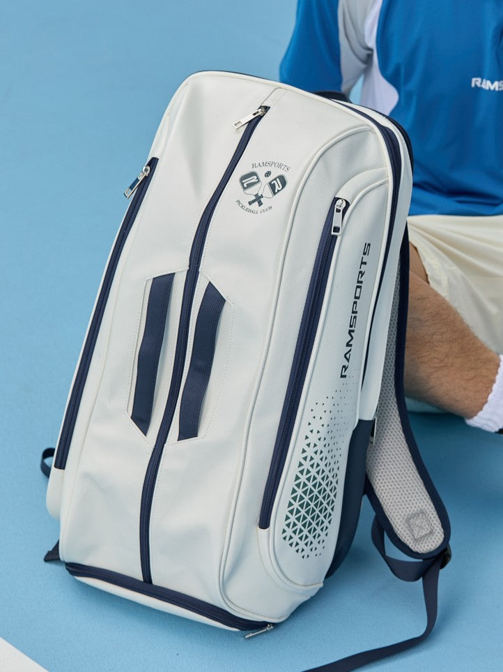 Cropped image - Bag-focused, Ramsports Light Court Luxe Tot bag resting on the ground, leaning against a male model